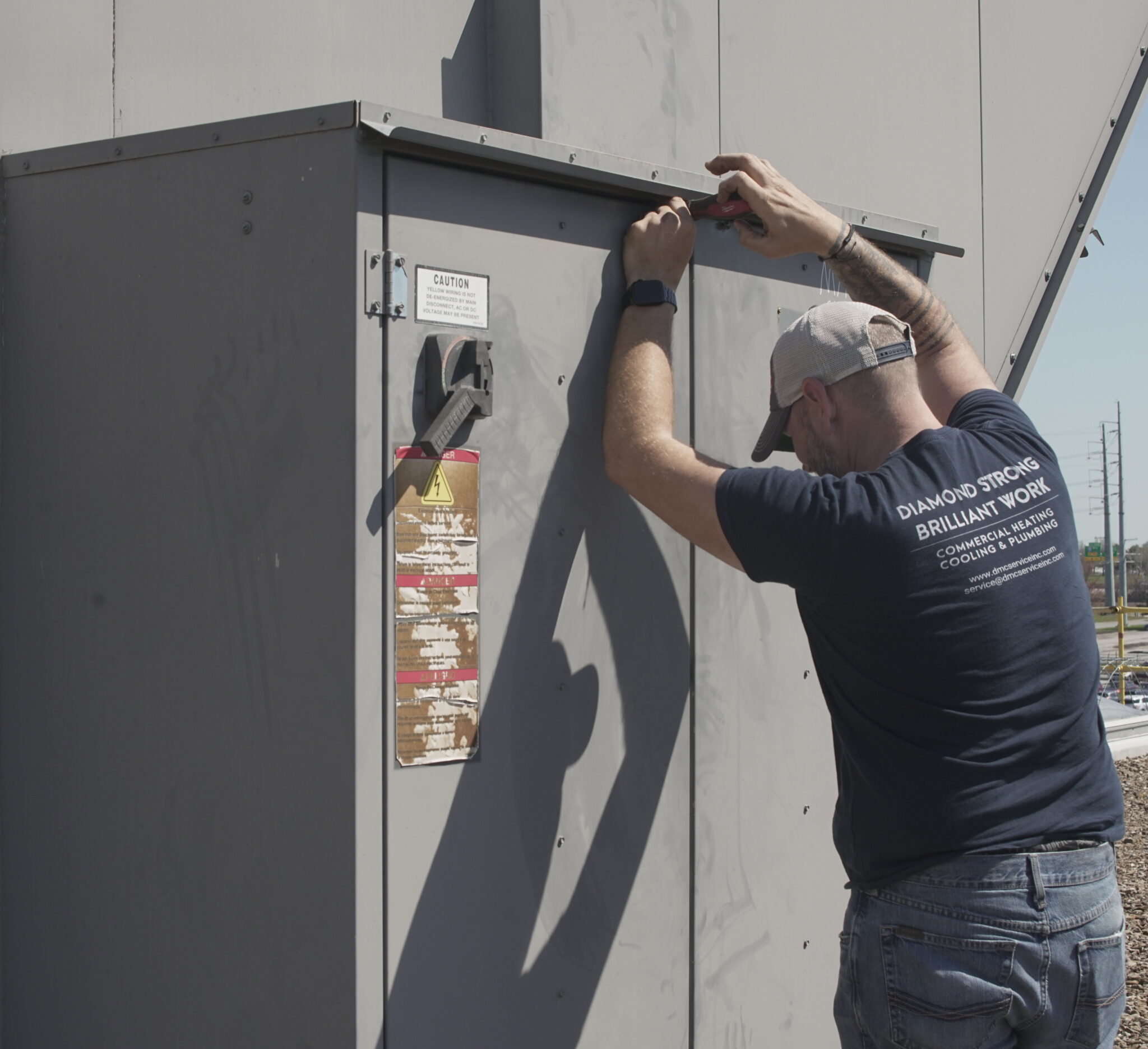 DMC technician performing preventative maintenance on a commercial HVAC system